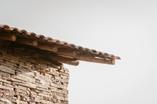 Close-up of a rustic stone wall and wooden roof with a minimalist design.